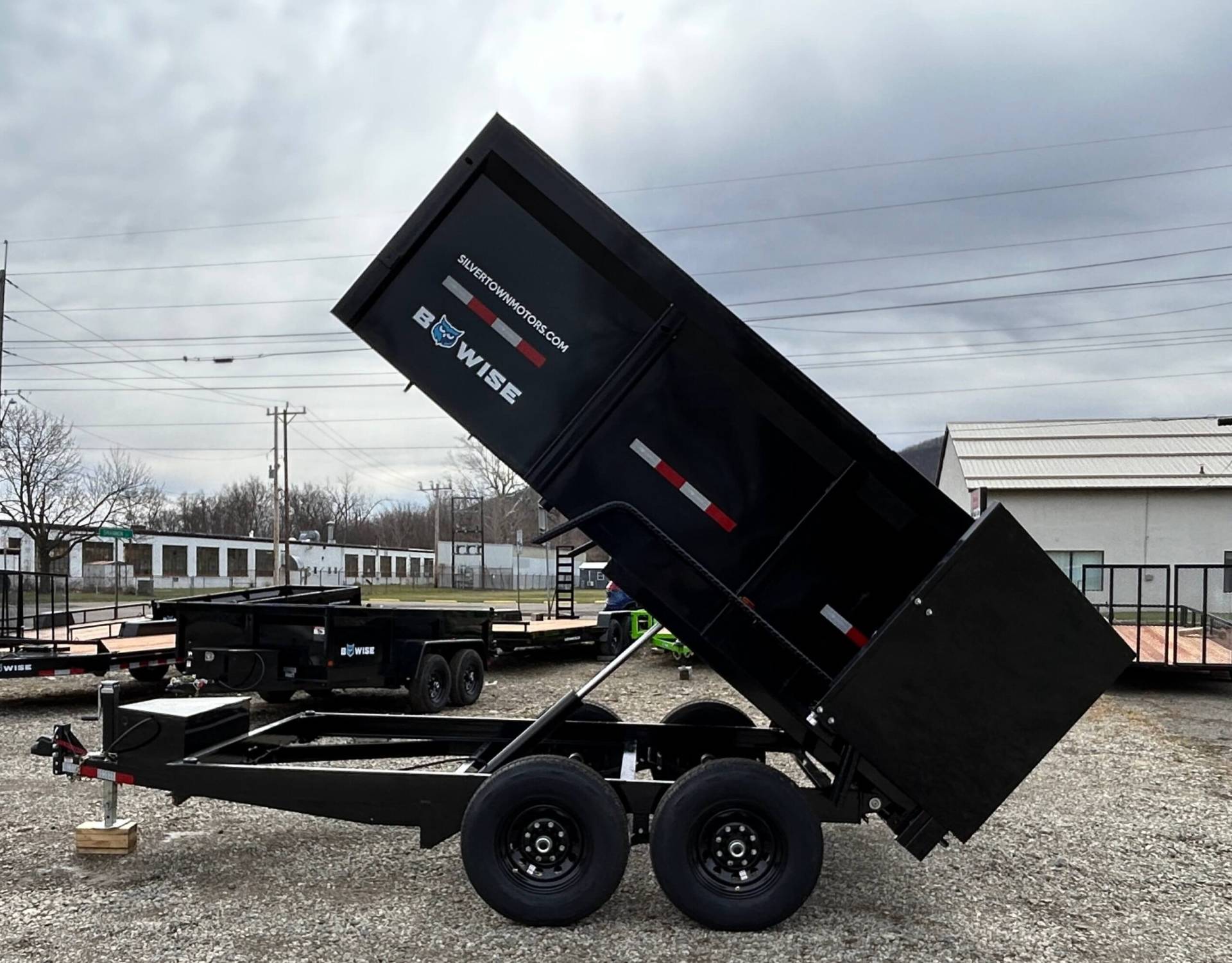Left side view of BWISE 7x12-12k High Sided Dump Trailer for sale with bed raised up